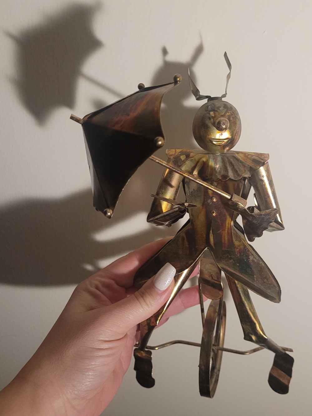 Vintage copper- and brass-toned metal art clown figurine riding a unicycle while